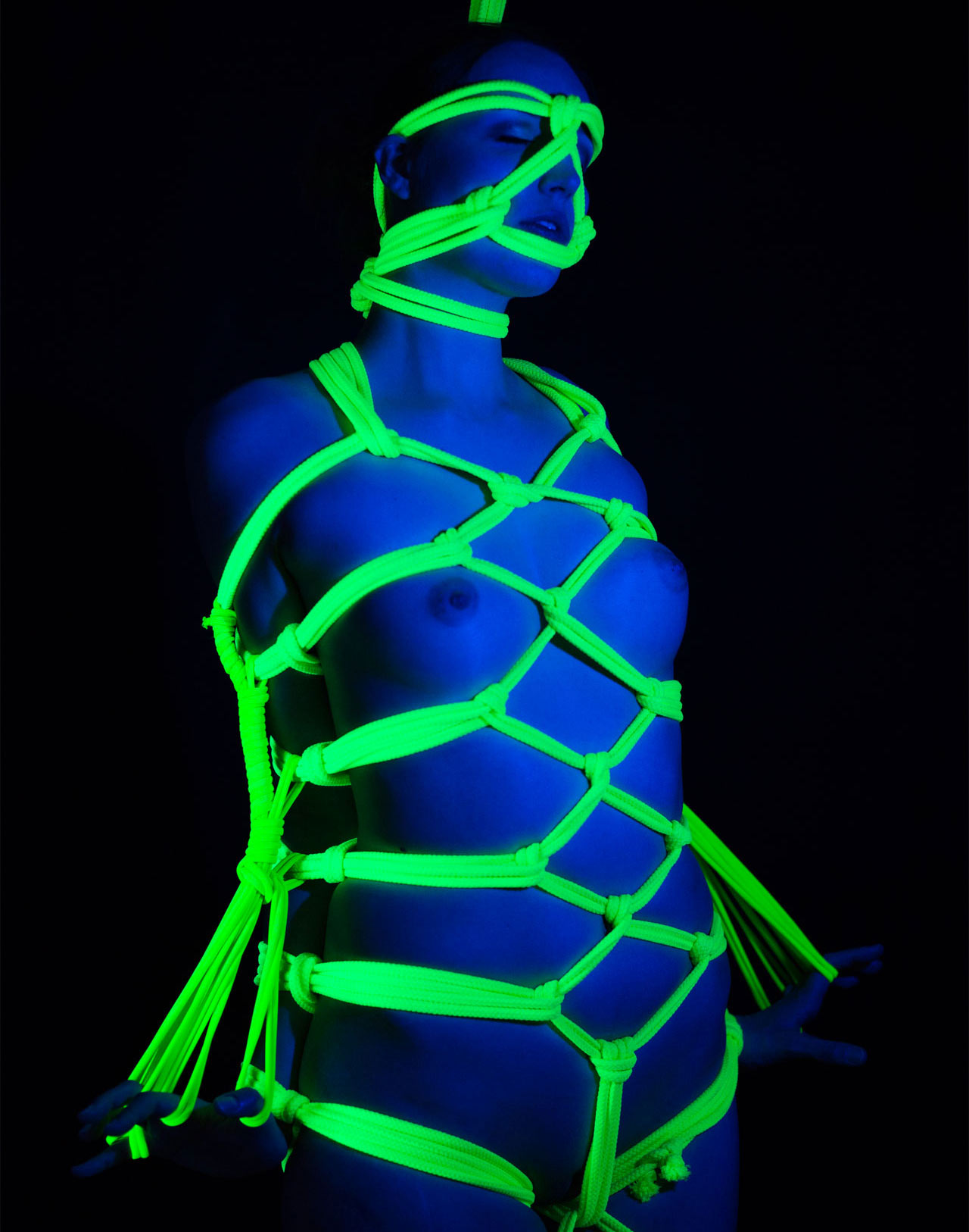 Bondage model DutchDame nude in black light Shibari by RopeMarks. Photo by Mew-Chiel.